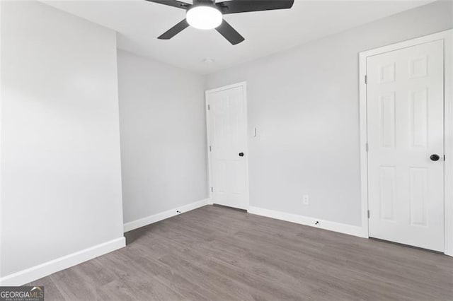 unfurnished bedroom featuring ceiling fan, baseboards, and wood finished floors