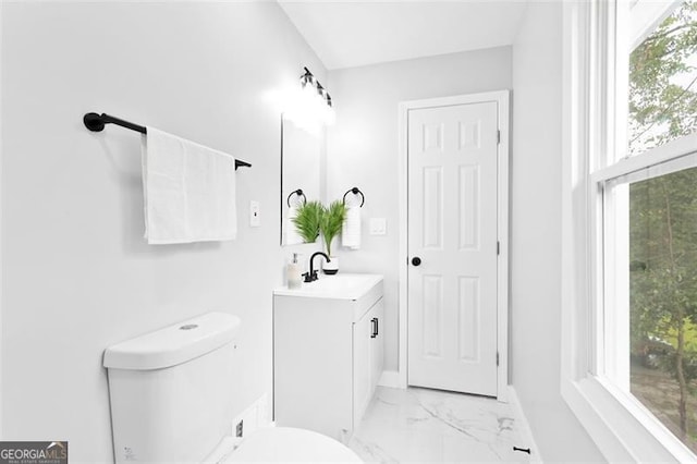 bathroom with marble finish floor, vanity, toilet, and baseboards