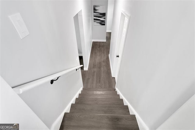 stairway featuring wood finished floors and baseboards