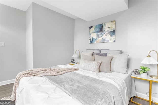 bedroom with dark wood-style flooring and baseboards