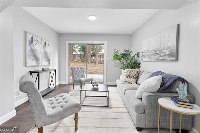 living area featuring visible vents, baseboards, and wood finished floors