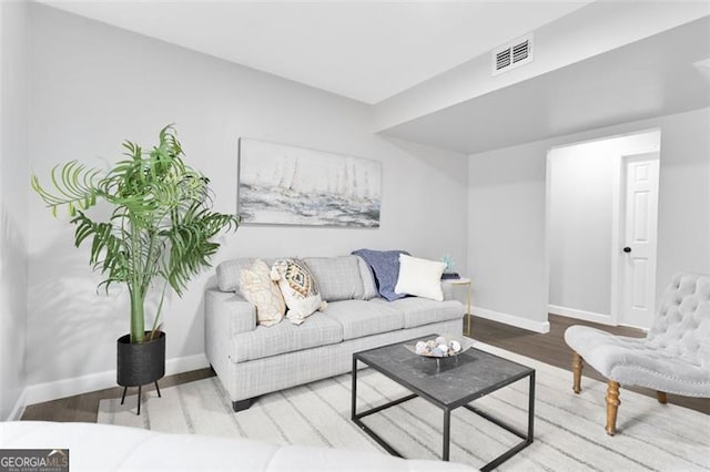 living area featuring light wood-style floors, baseboards, and visible vents