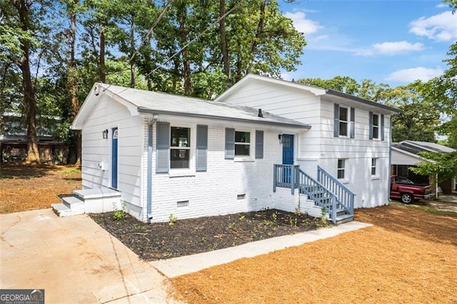 tri-level home featuring crawl space and brick siding