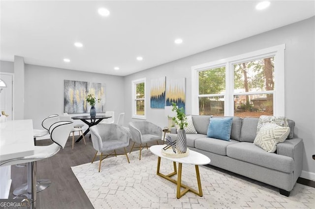 living area with light wood-style floors, baseboards, and recessed lighting