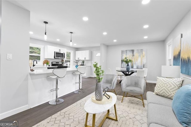 living room featuring dark wood-style floors, recessed lighting, and baseboards