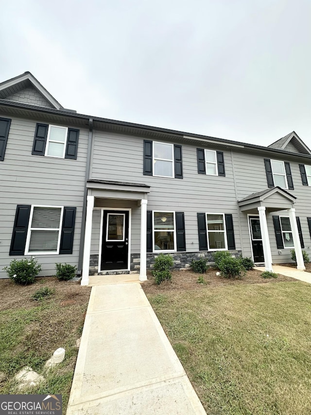 townhome / multi-family property with a front yard