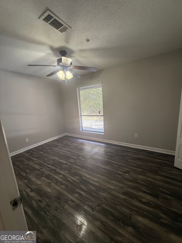 spare room with ceiling fan, dark wood-type flooring, and a textured ceiling