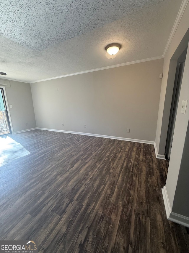 spare room with a textured ceiling, ornamental molding, and dark hardwood / wood-style floors