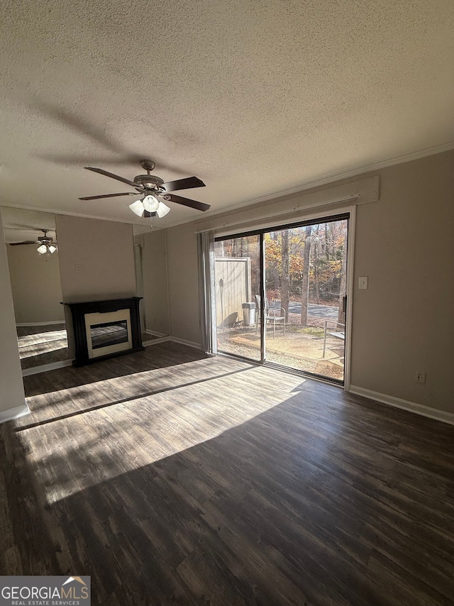 unfurnished living room featuring a textured ceiling, dark wood-type flooring, and crown molding