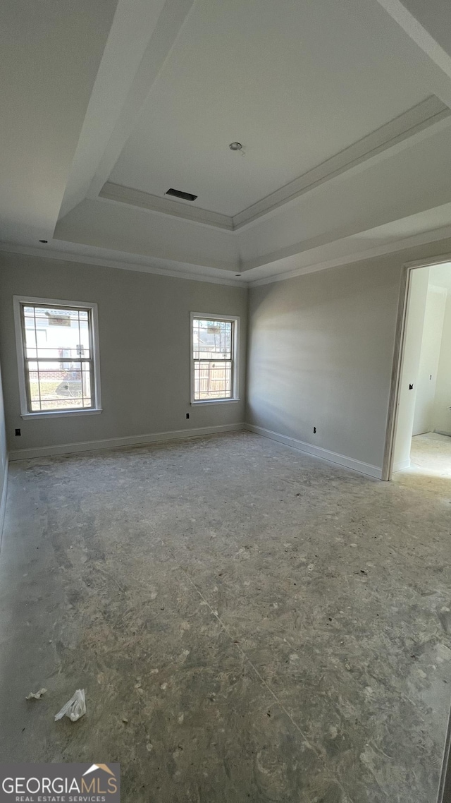 spare room featuring a tray ceiling and crown molding