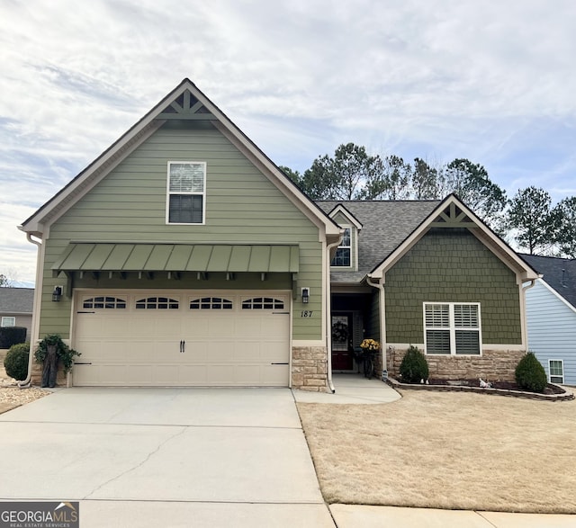 view of front of home with stone siding, an attached garage, and concrete driveway