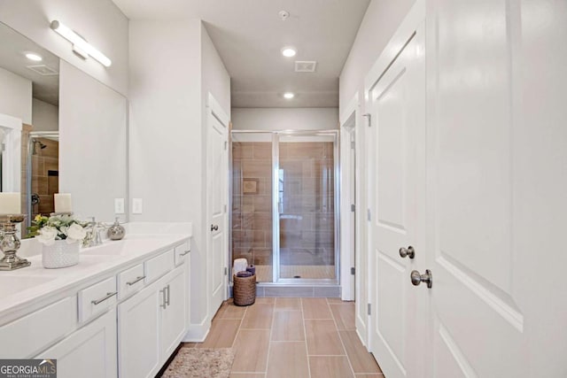 bathroom featuring recessed lighting, a shower stall, and double vanity
