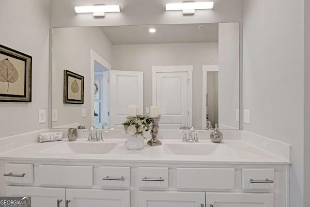 full bath with double vanity, a sink, and toilet