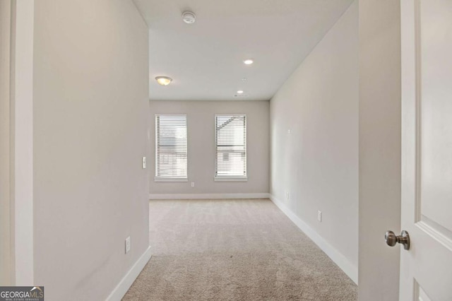empty room with light carpet, baseboards, and recessed lighting