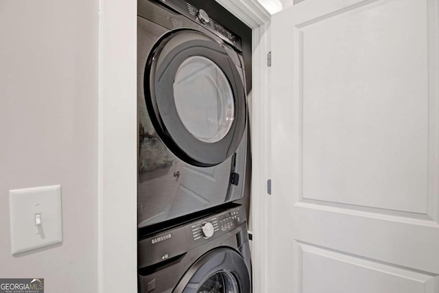 clothes washing area featuring laundry area and stacked washer / dryer