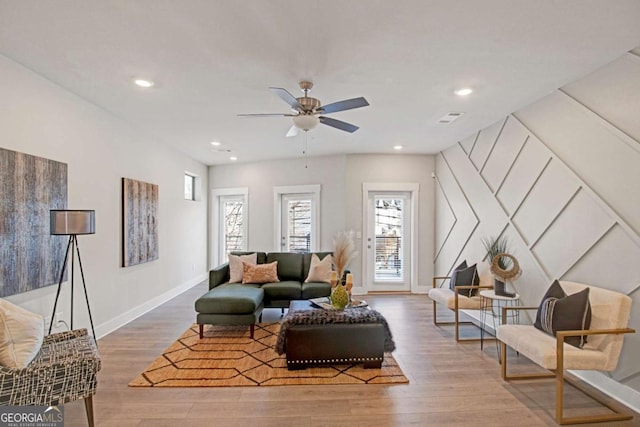 living area featuring recessed lighting, wood finished floors, a ceiling fan, visible vents, and baseboards