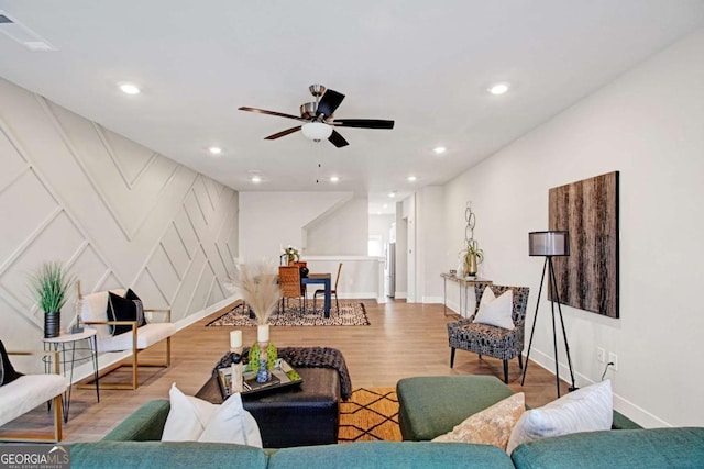 living room featuring baseboards, visible vents, wood finished floors, and recessed lighting