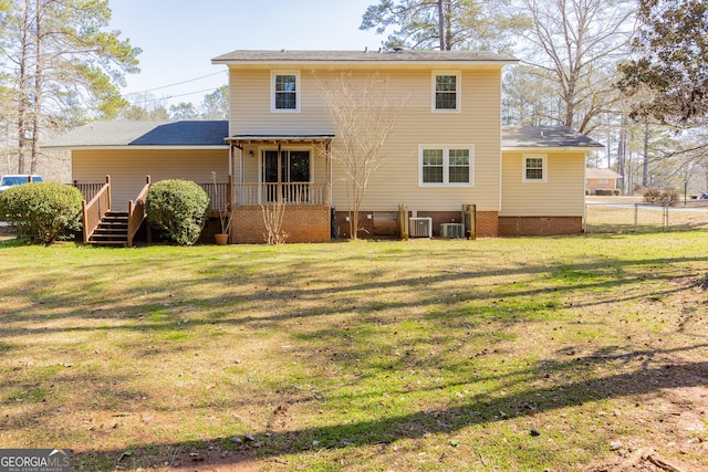 back of property with central AC, a lawn, a deck, and fence