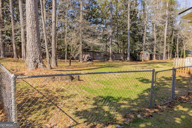 view of yard with a storage shed, an outbuilding, and a fenced backyard