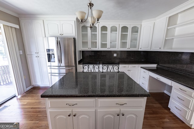 kitchen featuring white cabinets, stainless steel fridge, glass insert cabinets, and a center island