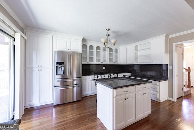 kitchen with glass insert cabinets, a center island, white cabinets, and stainless steel refrigerator with ice dispenser