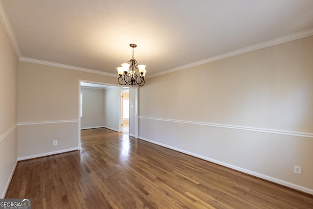 empty room with baseboards, a chandelier, wood finished floors, and ornamental molding