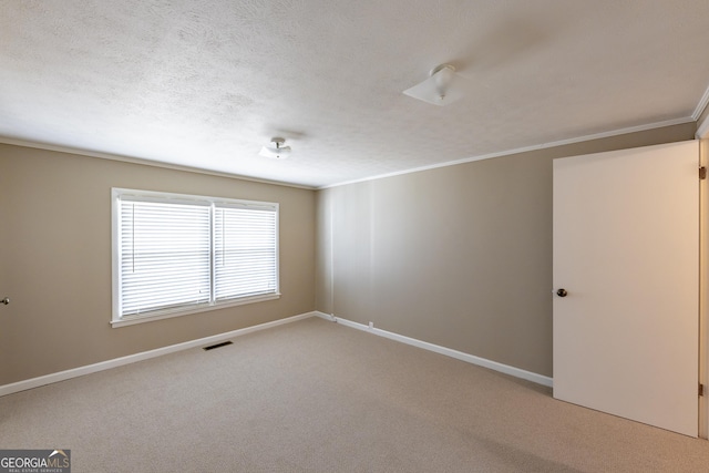 carpeted empty room featuring ornamental molding, visible vents, a textured ceiling, and baseboards