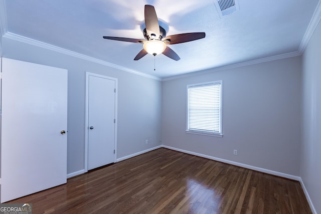 empty room featuring ceiling fan, dark wood-style flooring, visible vents, baseboards, and crown molding