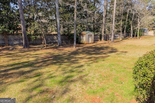 view of yard with a fenced backyard, an outdoor structure, and a storage shed