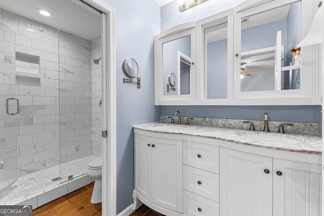 bathroom featuring vanity, walk in shower, toilet, and hardwood / wood-style floors