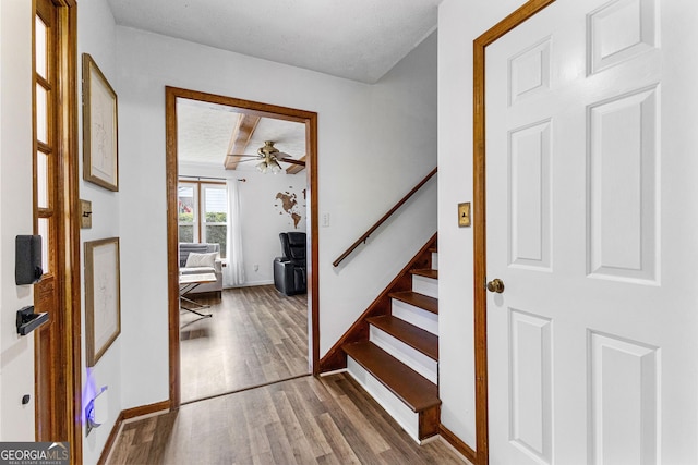 entryway with hardwood / wood-style flooring, ceiling fan, and a textured ceiling