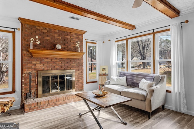 living room featuring hardwood / wood-style floors, beamed ceiling, and a textured ceiling