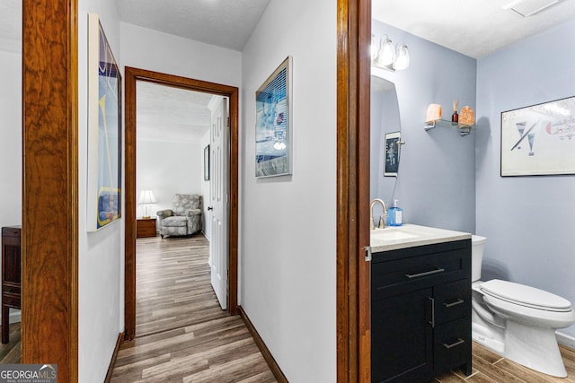 hallway featuring hardwood / wood-style floors, sink, and a textured ceiling