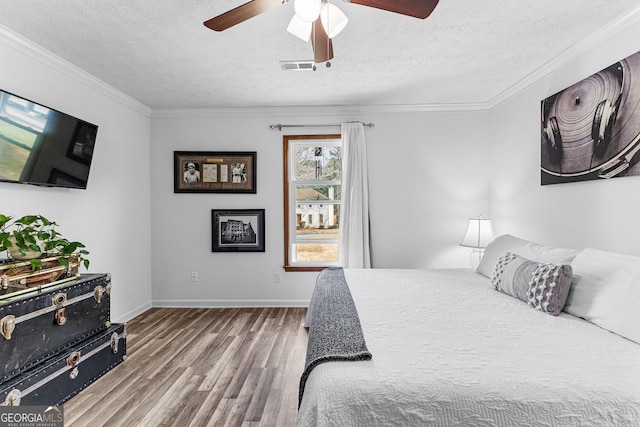 bedroom with hardwood / wood-style flooring, ornamental molding, and a textured ceiling