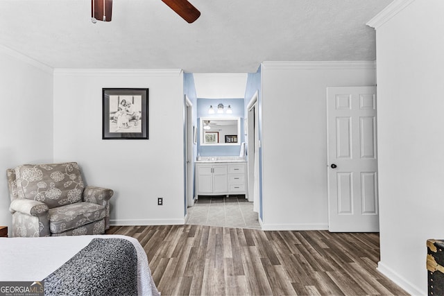 bedroom with hardwood / wood-style floors, crown molding, connected bathroom, and ceiling fan