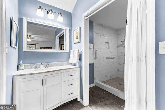 bathroom with ceiling fan, vanity, a shower with curtain, and tile patterned floors