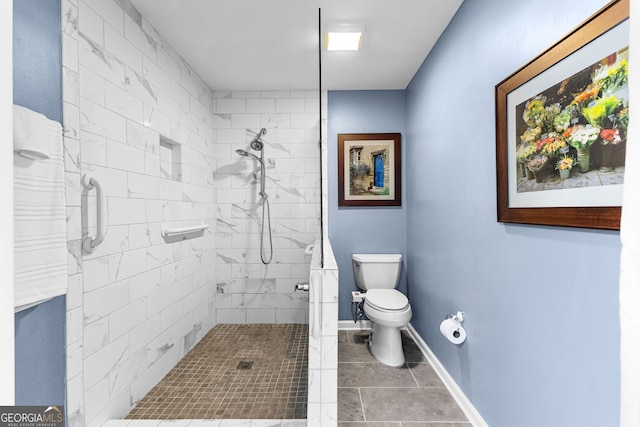 bathroom featuring a tile shower and toilet