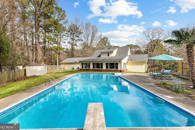 view of swimming pool with a storage unit, a patio area, and a diving board