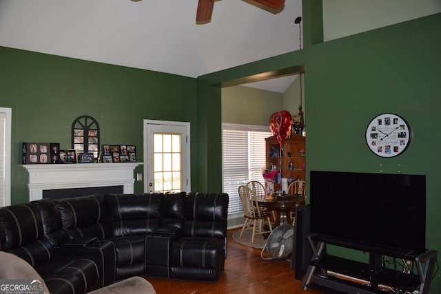 living room featuring a fireplace, dark wood-type flooring, a ceiling fan, and vaulted ceiling