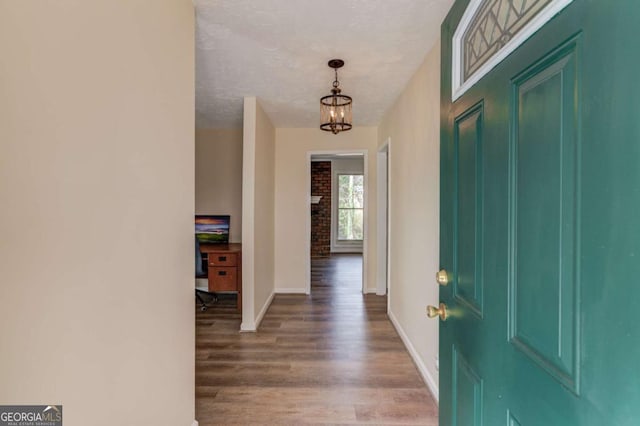 entrance foyer with an inviting chandelier, a textured ceiling, and hardwood / wood-style floors