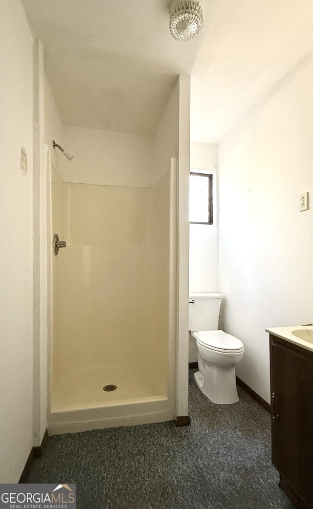 bathroom with toilet, vanity, and a shower