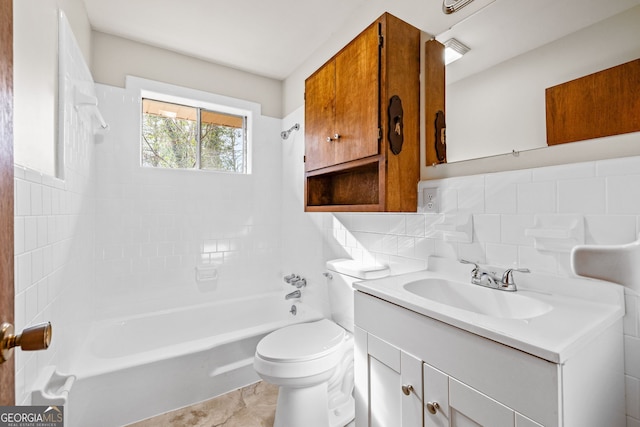 full bathroom with tile walls, vanity, tiled shower / bath combo, toilet, and tasteful backsplash