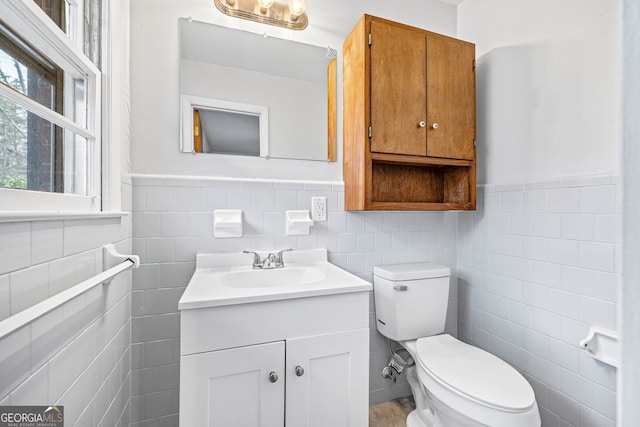 bathroom featuring tile walls, toilet, and vanity