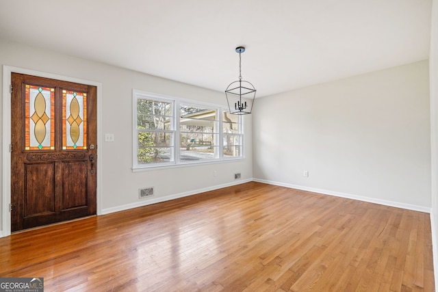 entrance foyer with light hardwood / wood-style floors and an inviting chandelier