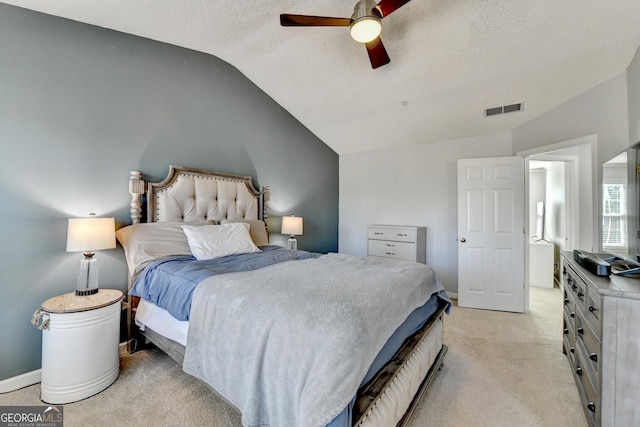 bedroom with visible vents, vaulted ceiling, light carpet, and baseboards