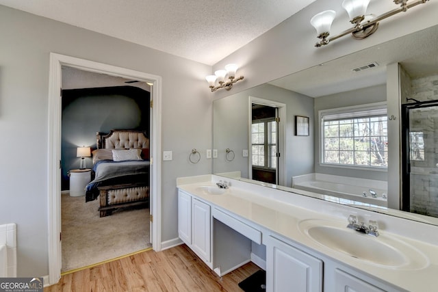 full bathroom with a sink, a garden tub, ensuite bath, and visible vents