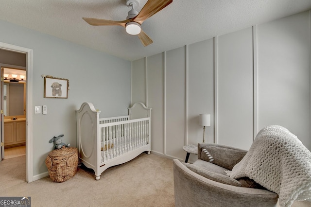 bedroom featuring light carpet, a textured ceiling, a ceiling fan, and baseboards