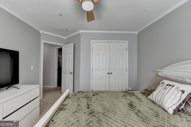 bedroom with light carpet, a ceiling fan, a textured ceiling, crown molding, and a closet