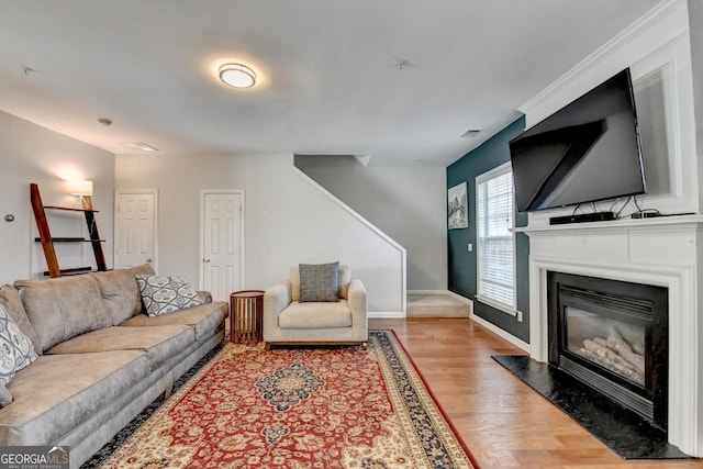 living area featuring a fireplace, baseboards, and wood finished floors