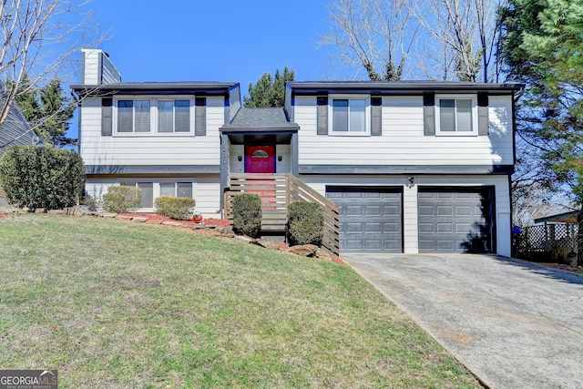 bi-level home with driveway, a front lawn, a chimney, and an attached garage